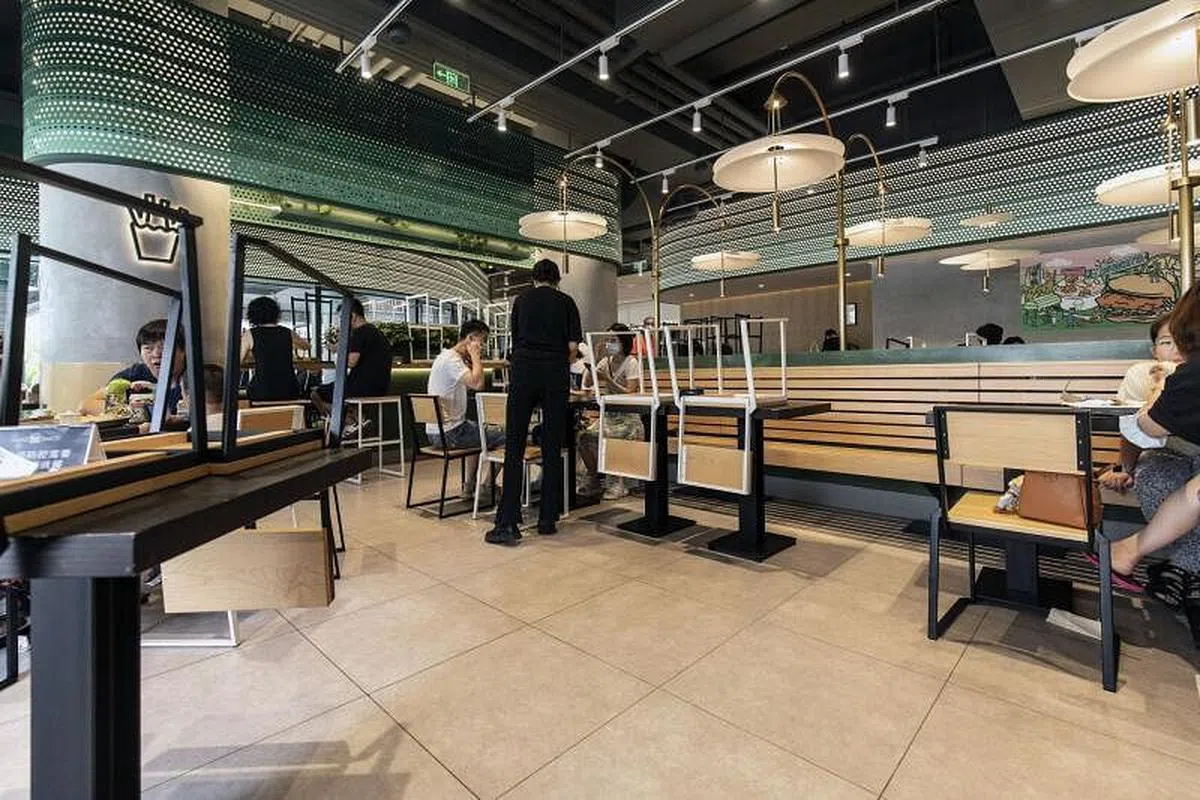 疫情封控时期，整个社会的经济运行都受到很大冲击，其中又以零售业、餐饮业为主的中小企业首当其冲。图为上海一家餐厅在社交安全措施下营业。（彭博社）