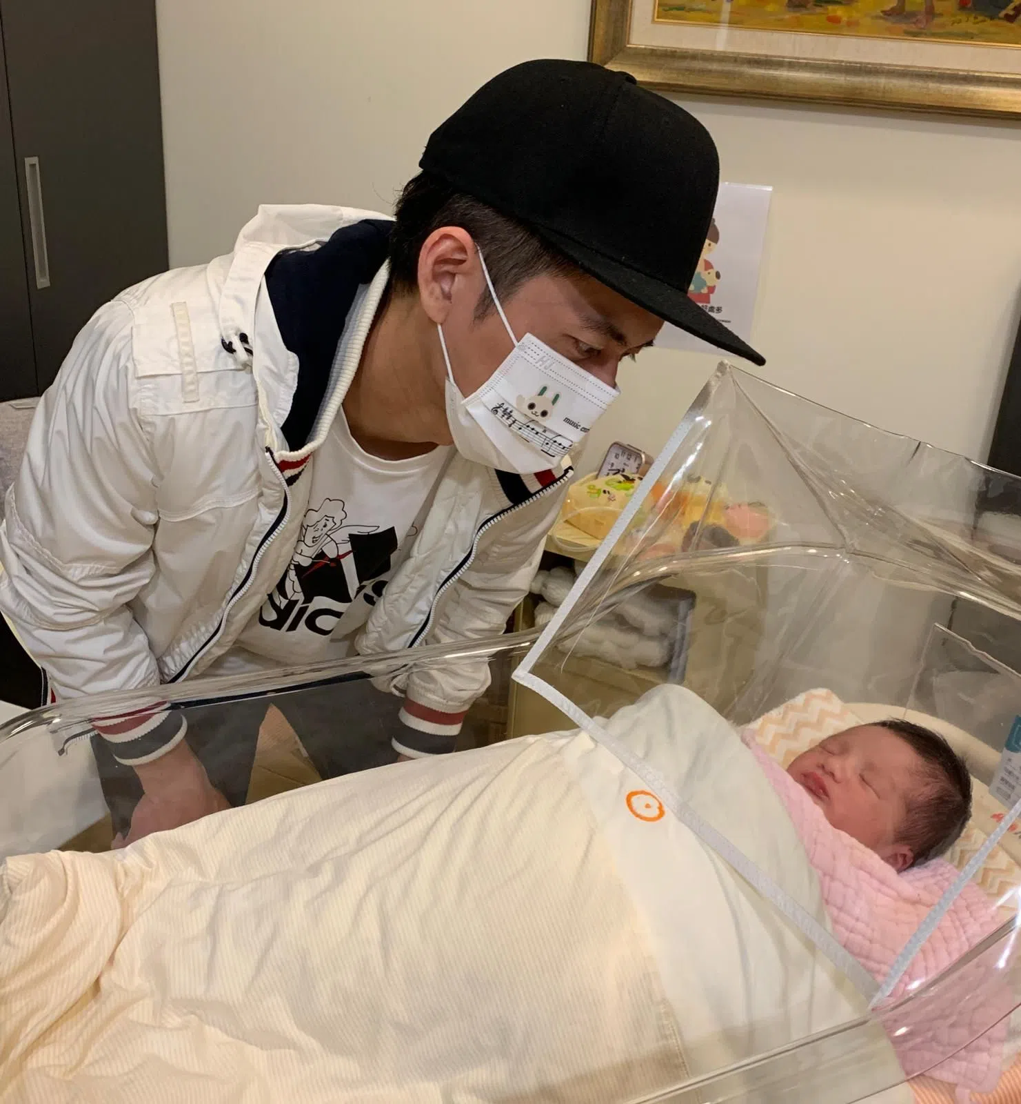 眼神充满爱！新手爸爸游政豪在医院望着儿子。（潘嘉丽提供）