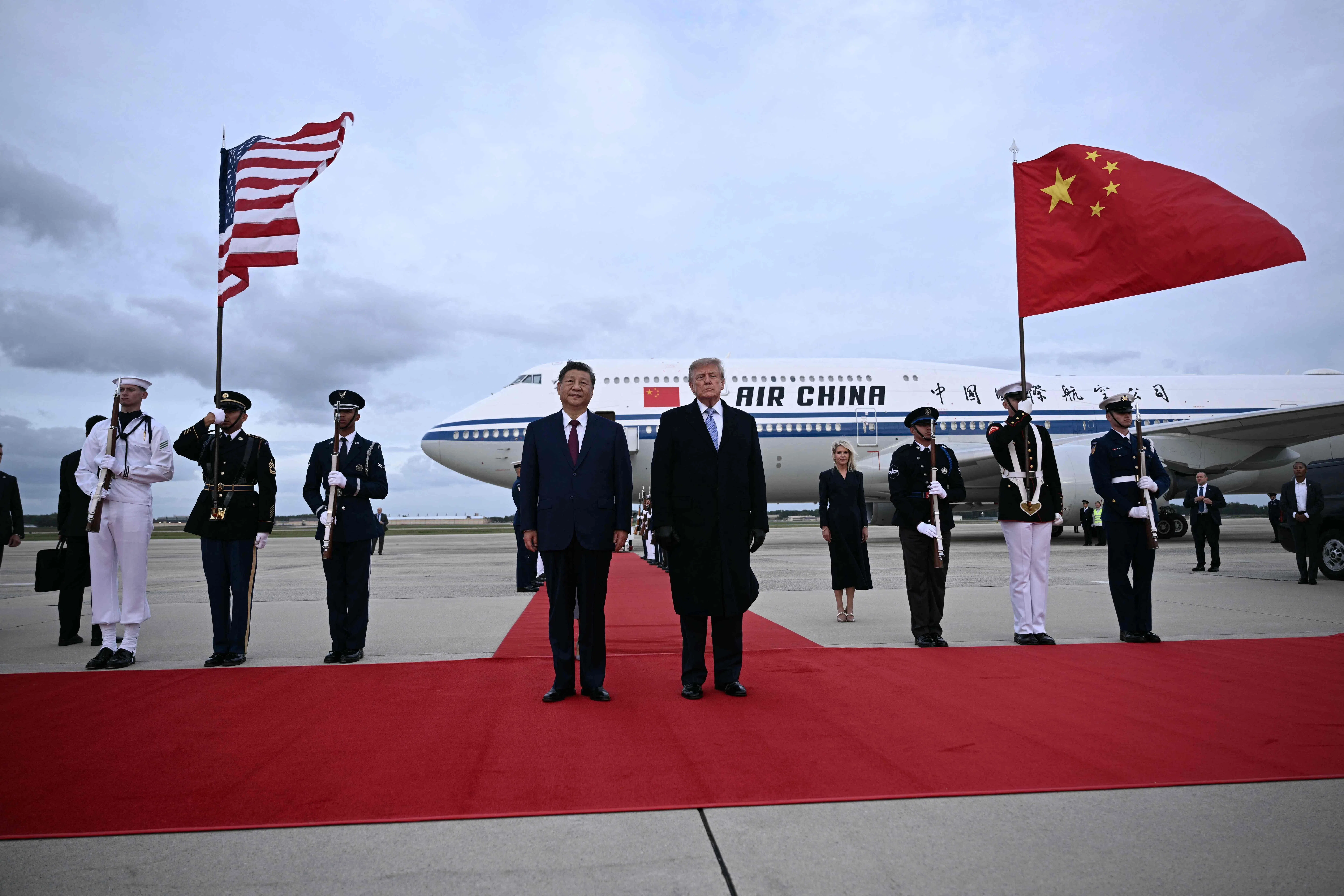 军乐演奏间，特朗普（右）与习近平并肩站在跑道红毯上，随后两架B-1轰炸机呼啸着划过上空。（法新社）