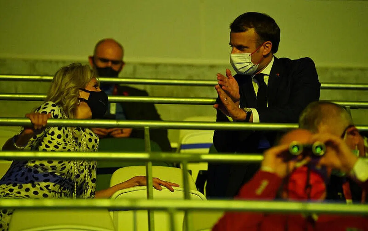 法国总统马克龙（右）和美国第一夫人吉尔·拜登（左）在开幕式的贵宾席上寒暄。日本内阁官房长官加藤胜信此前介绍说，大约15个国家和国际组织的领导人，70名内阁级官员将出席开幕式。马克龙于周五抵达东京，是唯一出席奥运会开幕式的发达国家首脑。法国巴黎也是下一届2024年夏季奥运会的东道主。（路透社） 