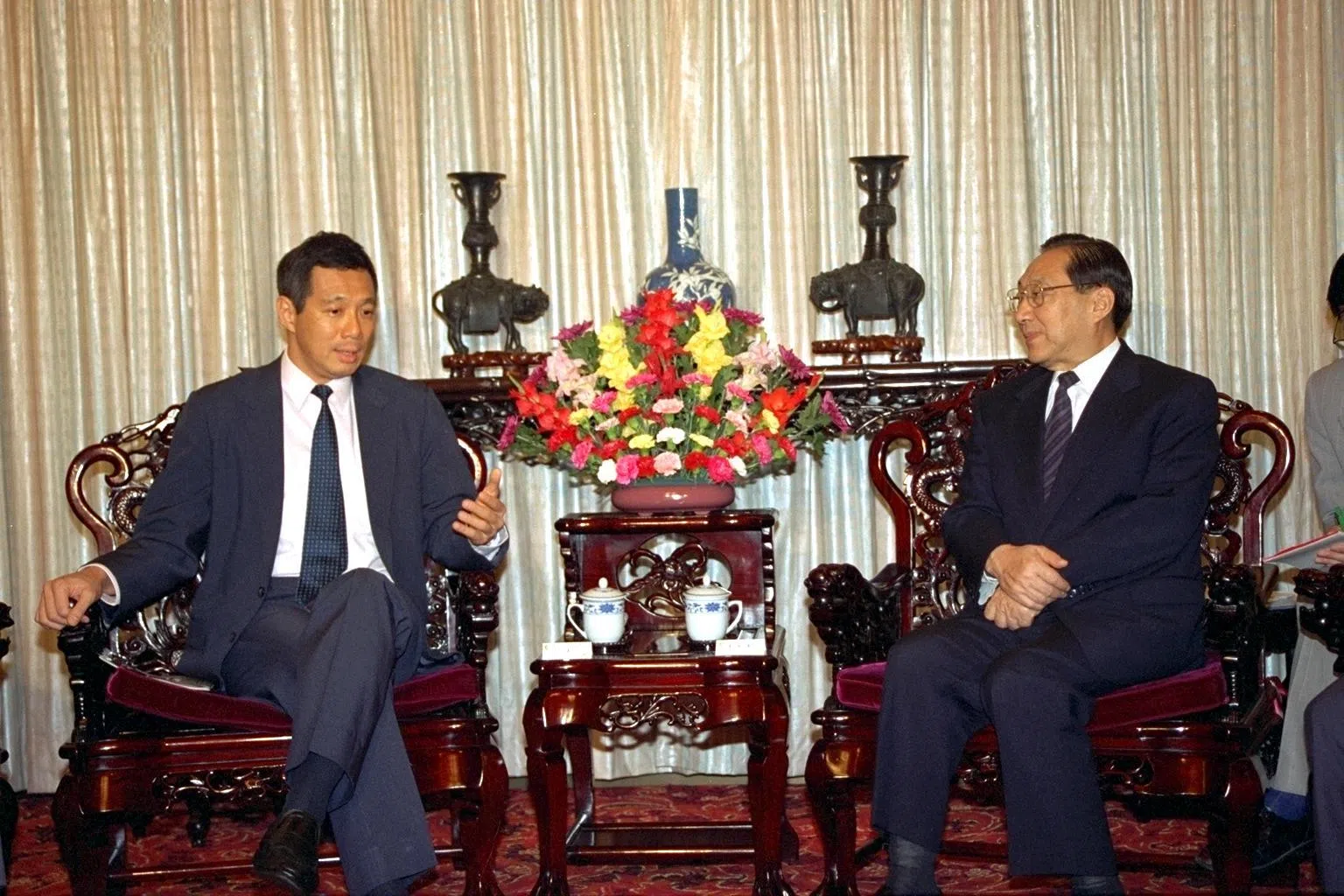 财经新闻副主任许丽卿曾是驻上海特派员，参与苏州工业园区的许多采访工作，包括199年时任副总理李显龙（左）到苏州参与苏州工业园区中新联合协调理事会第三次会议。图右为时任中国国务院副总理李岚清担任主席 。（陈来福摄）