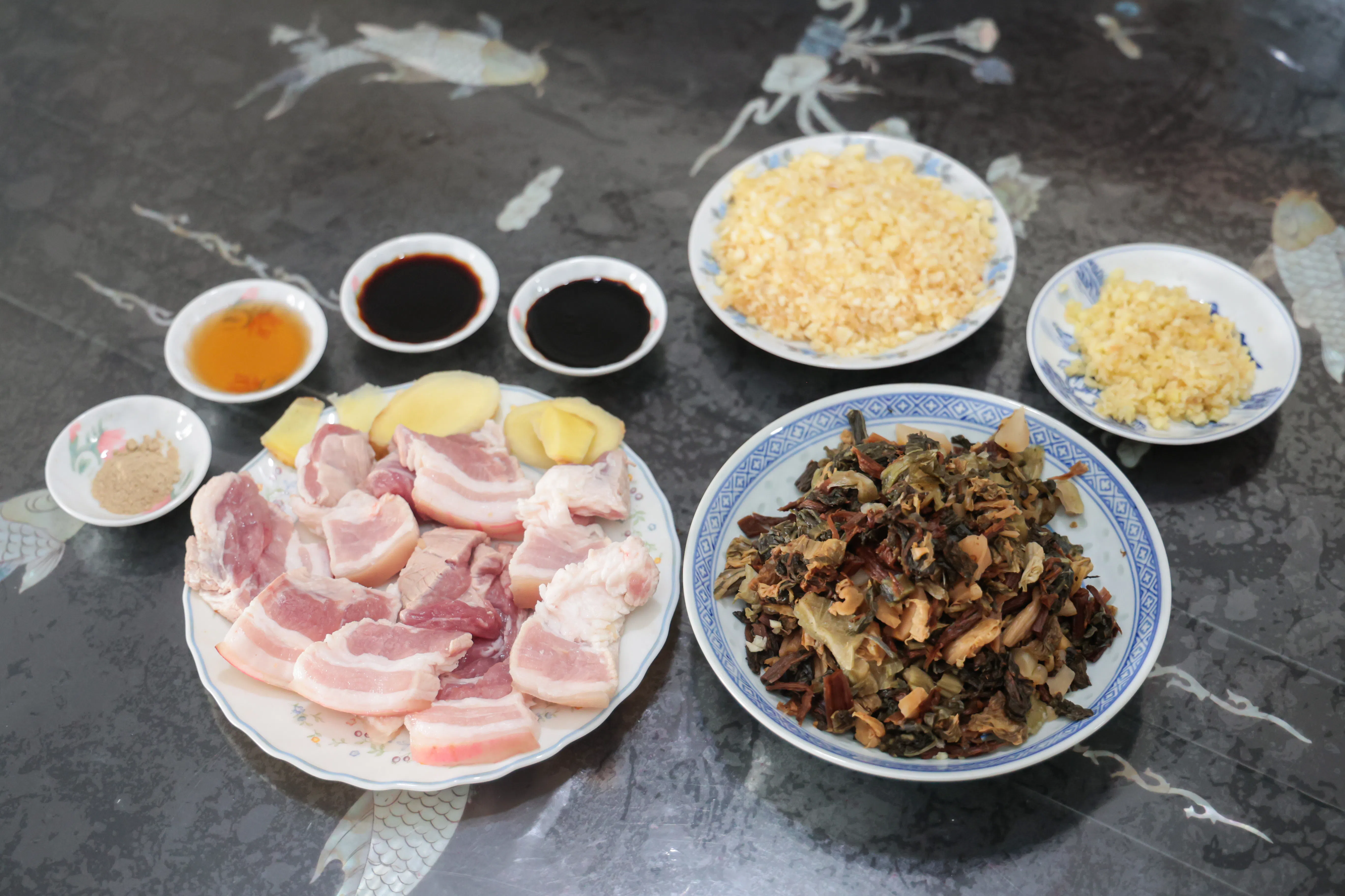 梅菜扣肉的主要食材有五花肉、咸梅菜、甜梅菜、姜片、蒜头等。（李冠卫摄）