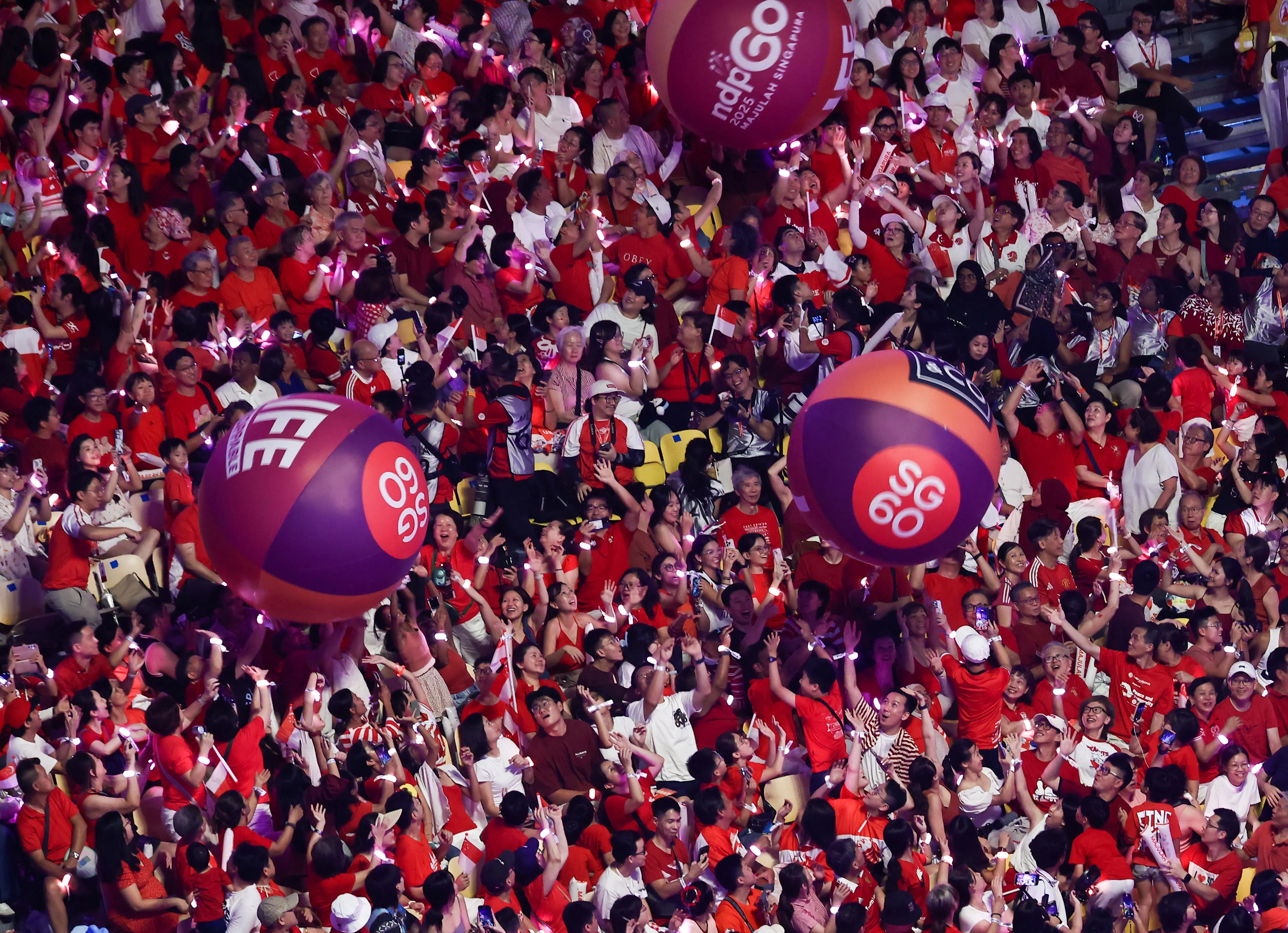 作为每年的国庆庆典传统，印有“SG60”字样的巨型气球从看台滚落，被无数双手托起、向前传递。就如过去60年，新加坡的成就也是一代代人接力努力，让梦想不断延续。（陈渊庄摄）