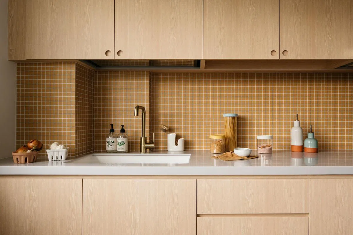 厨房防溅墙土黄色的马赛克瓷砖，呼应壁橱的颜色。