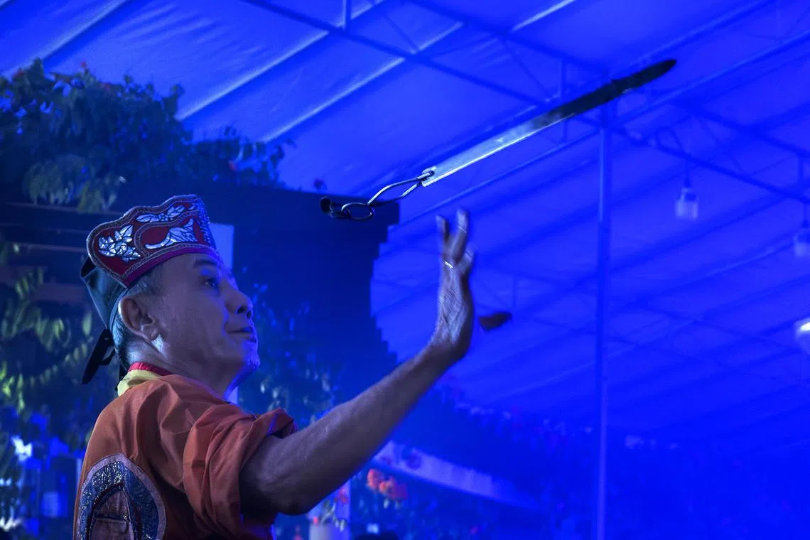 黎师傅从容舞动手中灼热的白钢剑。（龙国雄摄）