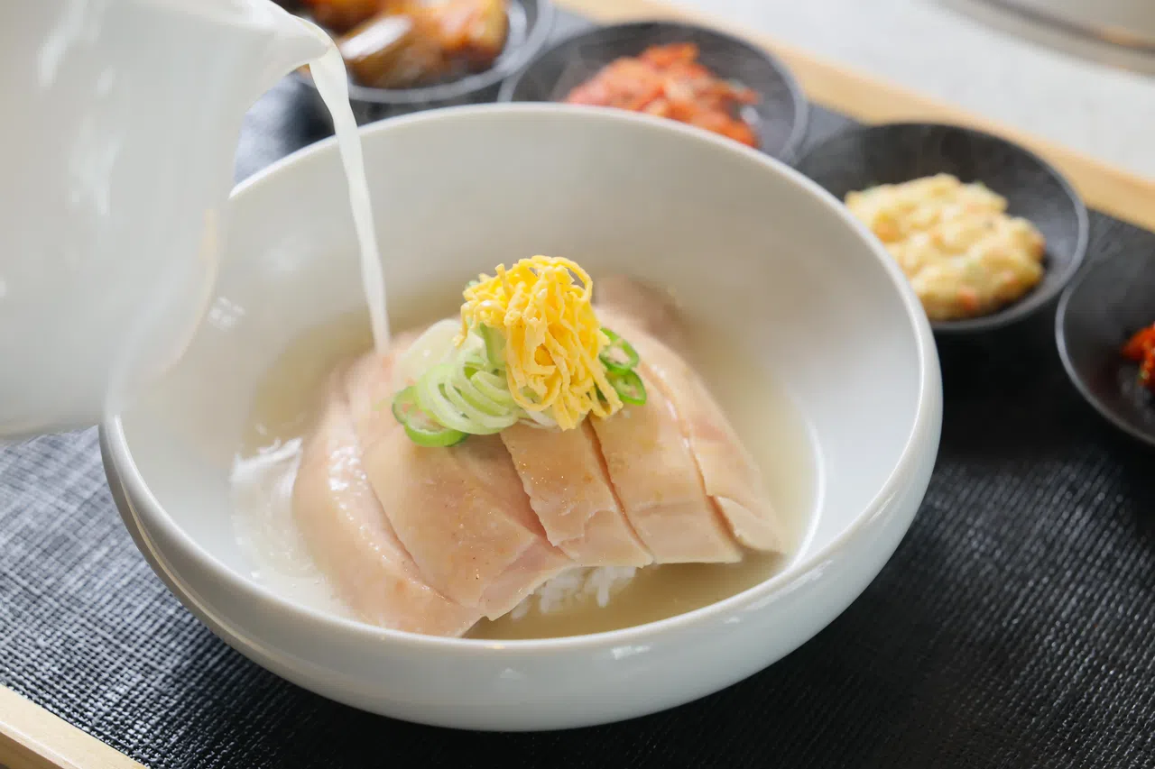 以清鸡汤为主材的韩式传统餐食组合，清淡不油腻，搭配米饭和小菜享用，有助养身提升元气。（龙国雄摄）