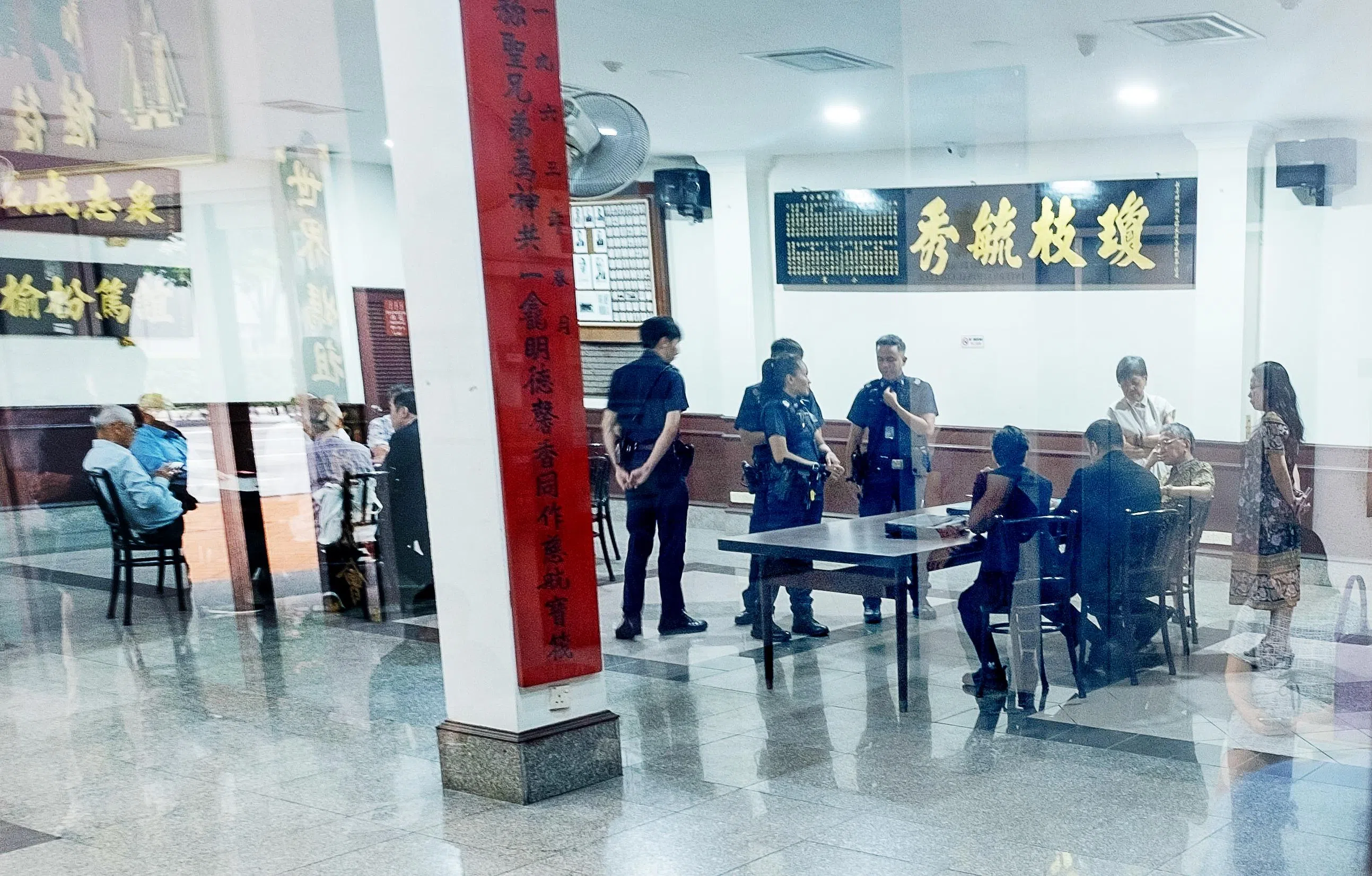 警员到场调解后，双方移步大堂闭门协商。右桌为符永平一方，左桌为王振胡一方。（特约骆辉煌摄）