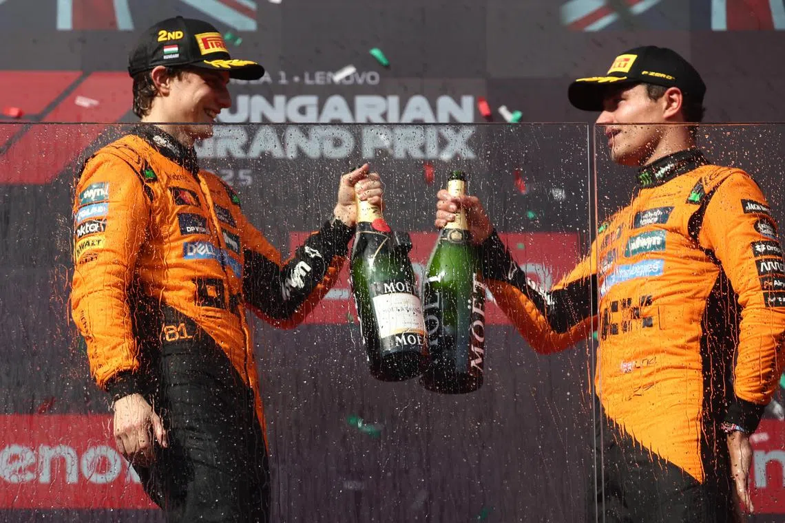 迈凯伦车手诺里斯（右）在夺冠后与队友皮亚斯特里开香槟庆祝。（路透社）