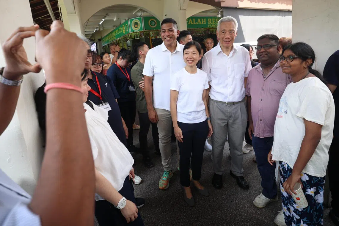 刘洁敏（左二）星期天（4月13日）早上与国务资政李显龙（左三）走访邻里时，与居民合照。左一为现任宏茂桥集选区议员杰乐大卫。（关俊威摄）