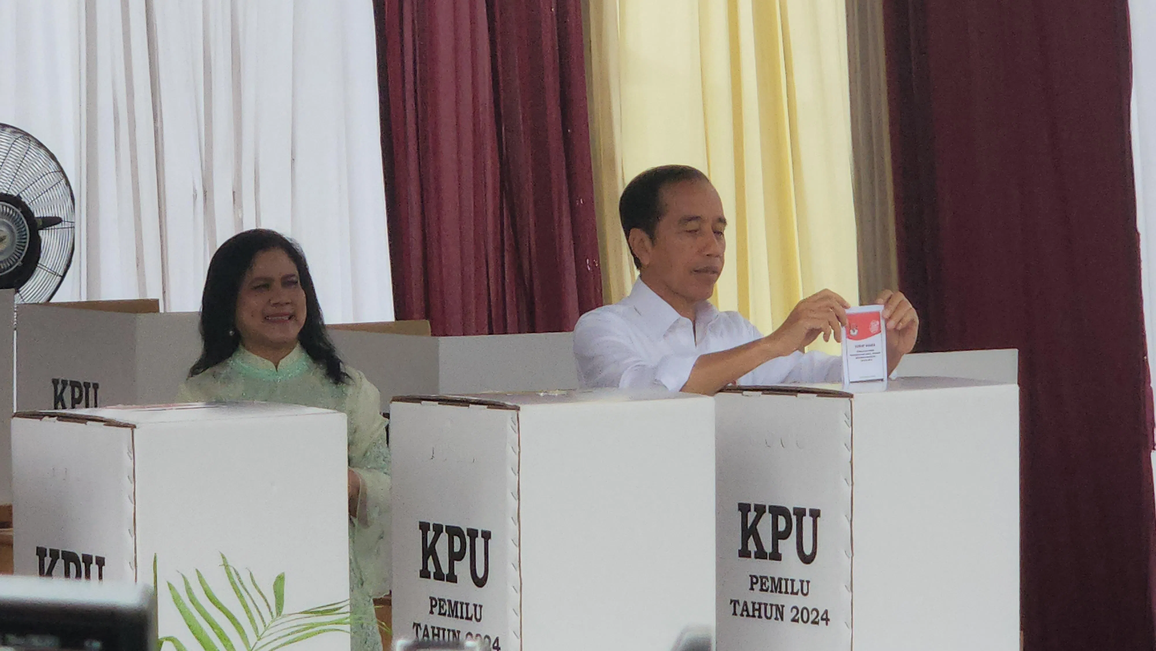 佐科（右）和伊莉亚娜（左）完成投票后，将选票置入投票箱。（蓝云舟摄）