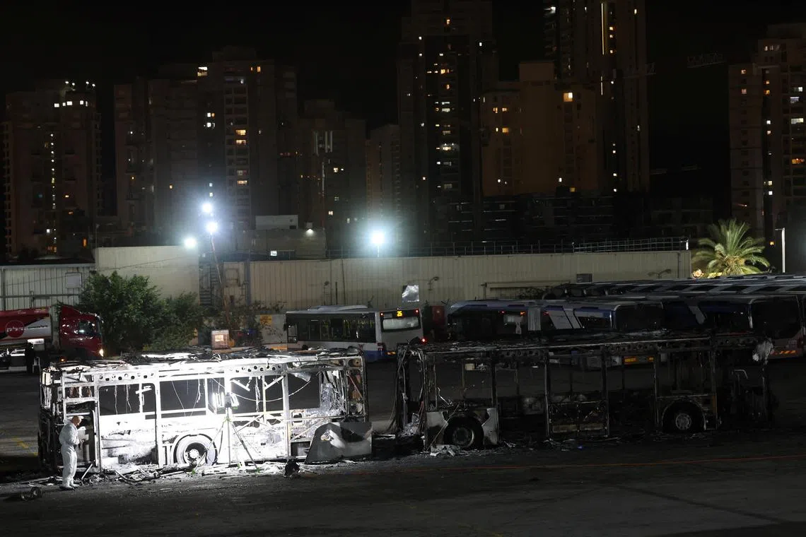 以色列中部城市巴特亚姆的三辆巴士发生爆炸，调查人员在其中一个案发现场进行技术取证。（路透社）