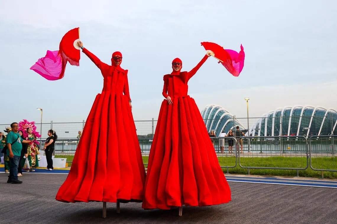 身着全红表演服，手持粉红色扇子，许雯萱与队友高俊翔在高跷上随着音乐起舞，动作轻盈而稳健。（林明顺摄）