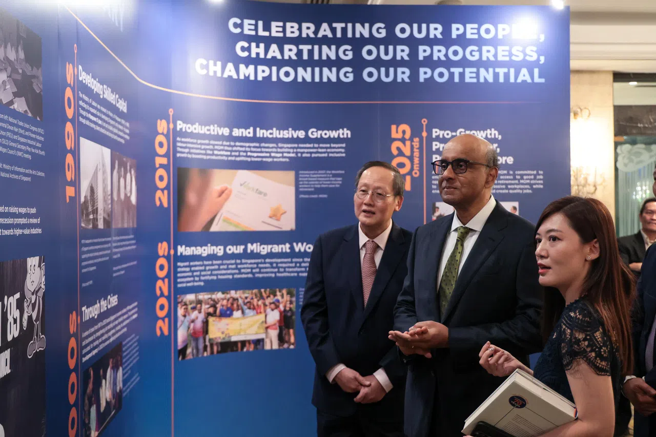 人力部举行70周年庆晚宴，尚达曼总统（中）是晚宴主宾，陪他参观场外展览的是人力部长兼贸工部第二部长陈诗龙医生（左）以及人力部工作准证司政策及策略处长周愉甜。（张俊杰摄）