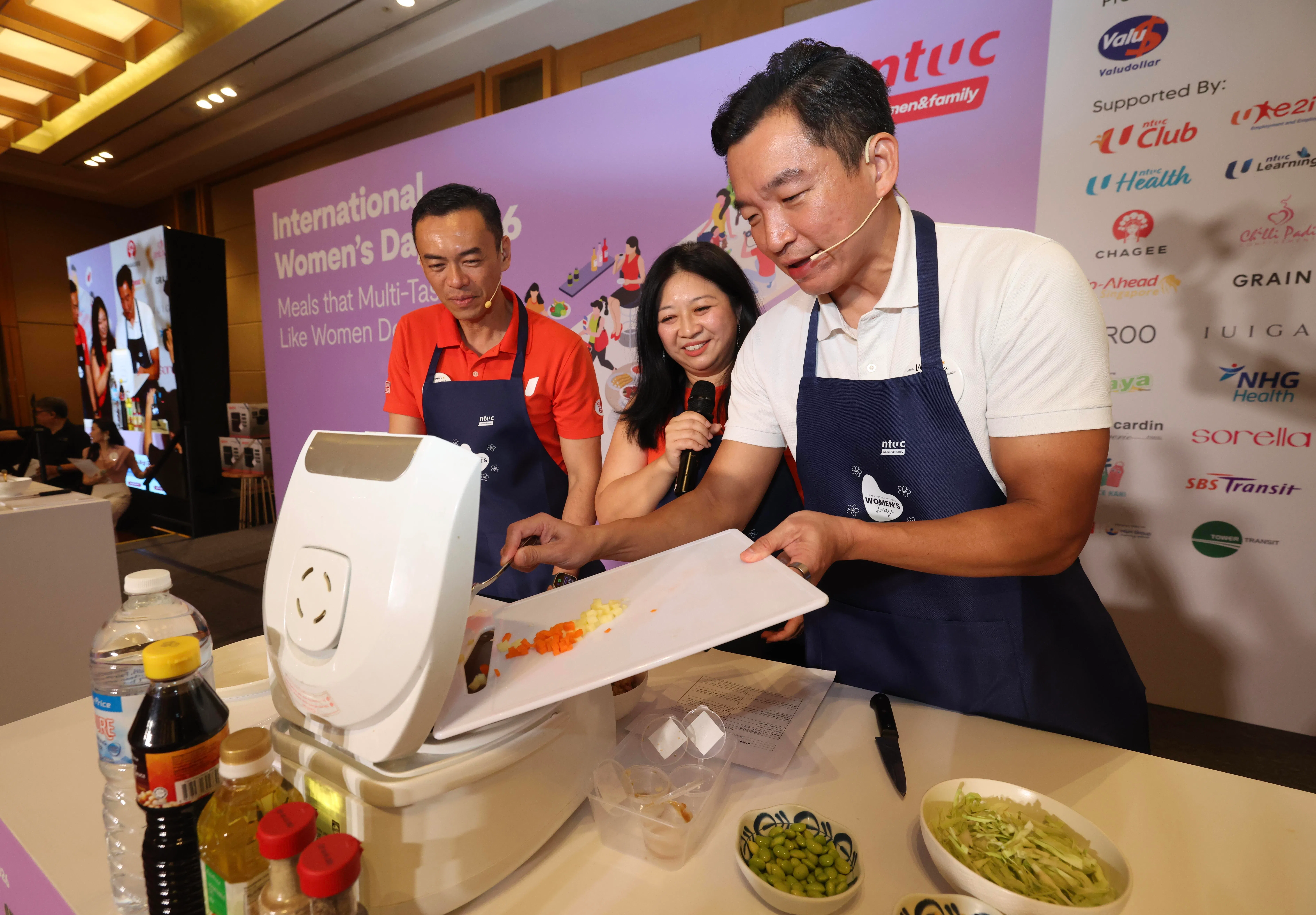 律政部兼社会及家庭发展部高级政务次长蔡瑞隆（右）和惹兰勿刹集选区议员文礼佳（左）也在杨涴淩（中）的指导下，共同完成荤素搭配的一锅煮炒饭。这个食谱由职总航空交通执行人员联合会会长卢裕城贡献。（郑一鸣摄）