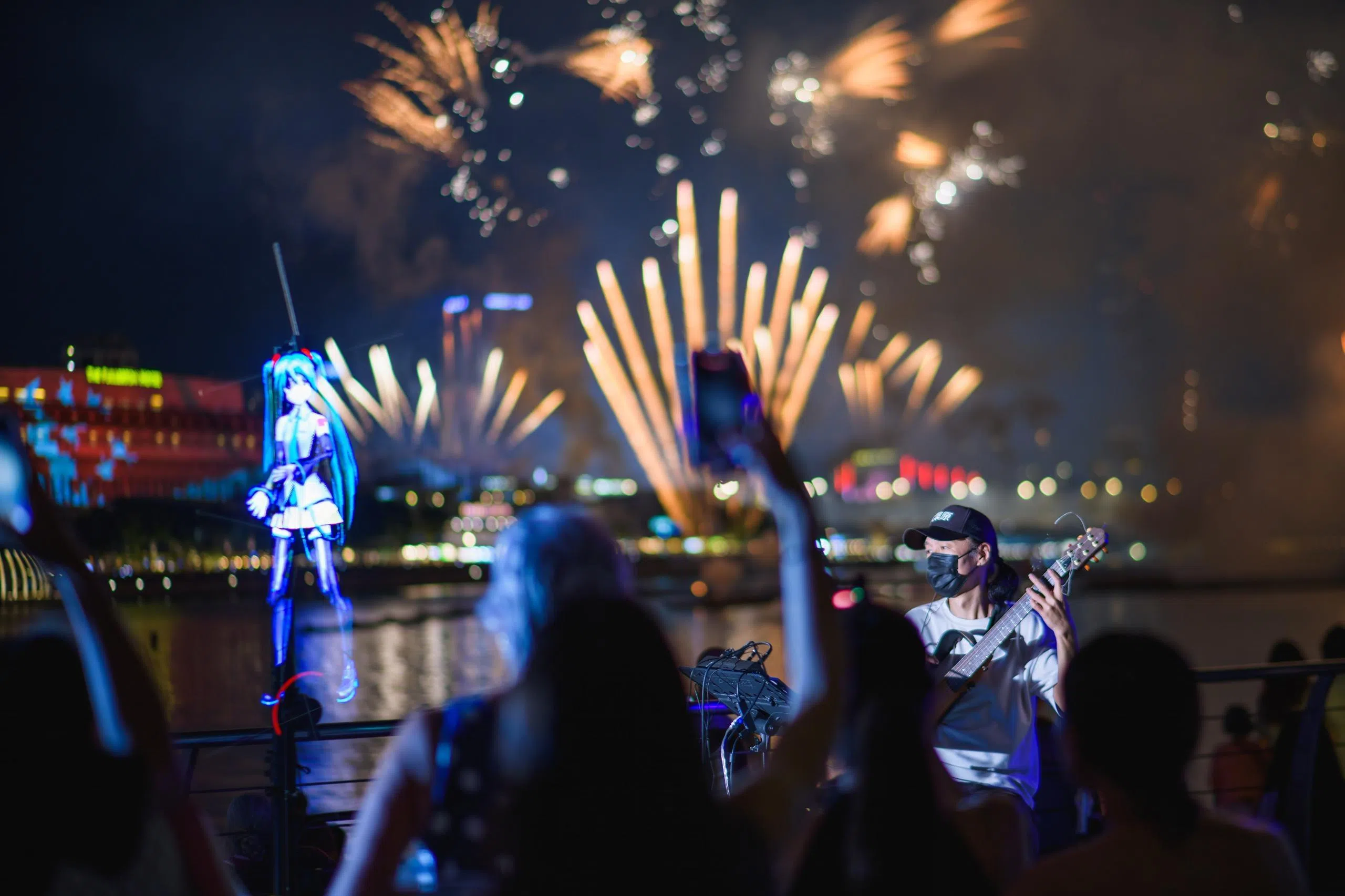 去年国庆日，丘荣发在滨海湾街头表演，璀璨烟花在身后绽放。（受访者提供）