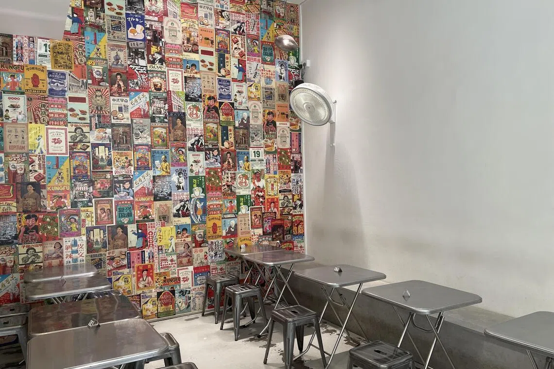 “一家人”的装饰墙上挂满怀旧海报，与不锈钢桌椅相映成趣。（黄靖晶摄）