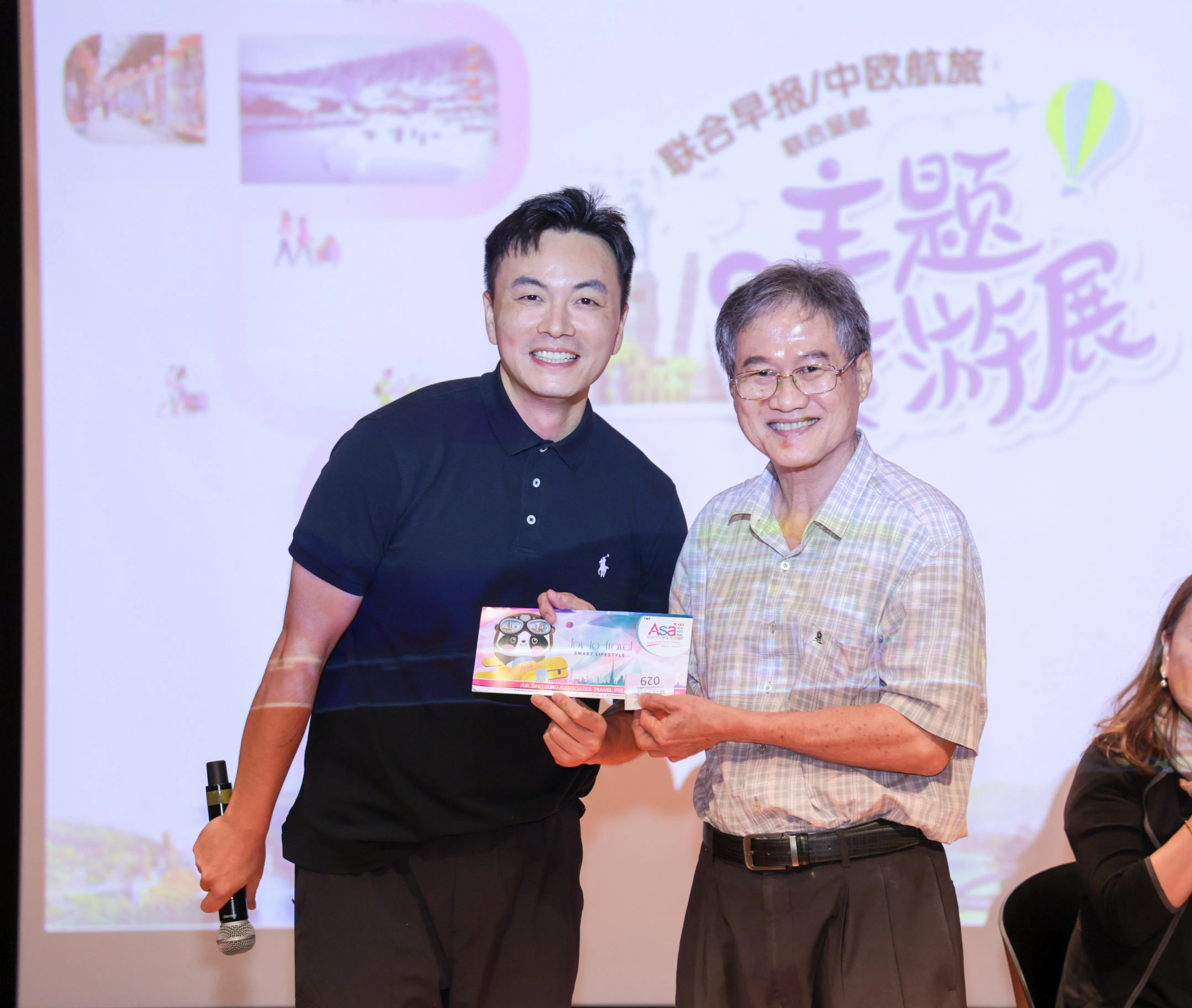 分享会嘉宾张家界广乘国际旅行社有限公司总经理卓湘涵（左）与第二场分享会获得200元旅游礼券的读者合影。（吴先邦摄）