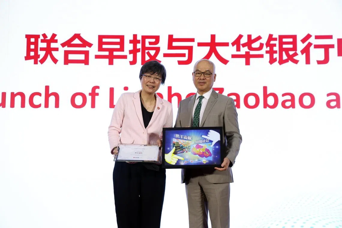 新报业媒体华文媒体集团社长李慧玲（左）与大华银行中国行长兼首席执行官符懋赞互赠佳礼，标志《联合早报》正式携手大华银行在中国开展公益合作项目。（邝启聪摄）