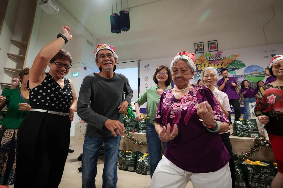 福善活跃乐龄中心工作人员和义工在舞台上献唱印度尼西亚歌曲《蜜糖与毒药》时，在台下的年长者随音乐旋律起舞。（张俊杰摄）