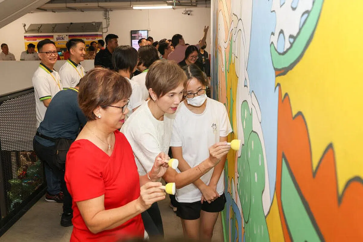 诺雅初院学生为玛丽蒙民众俱乐部创作壁画，出席开幕活动的嘉宾中区市长潘丽萍（左一）和通讯及新闻部长兼内政部第二部长杨莉明（左二）为壁画完成最后一个步骤的上色。（卓祾祎摄）