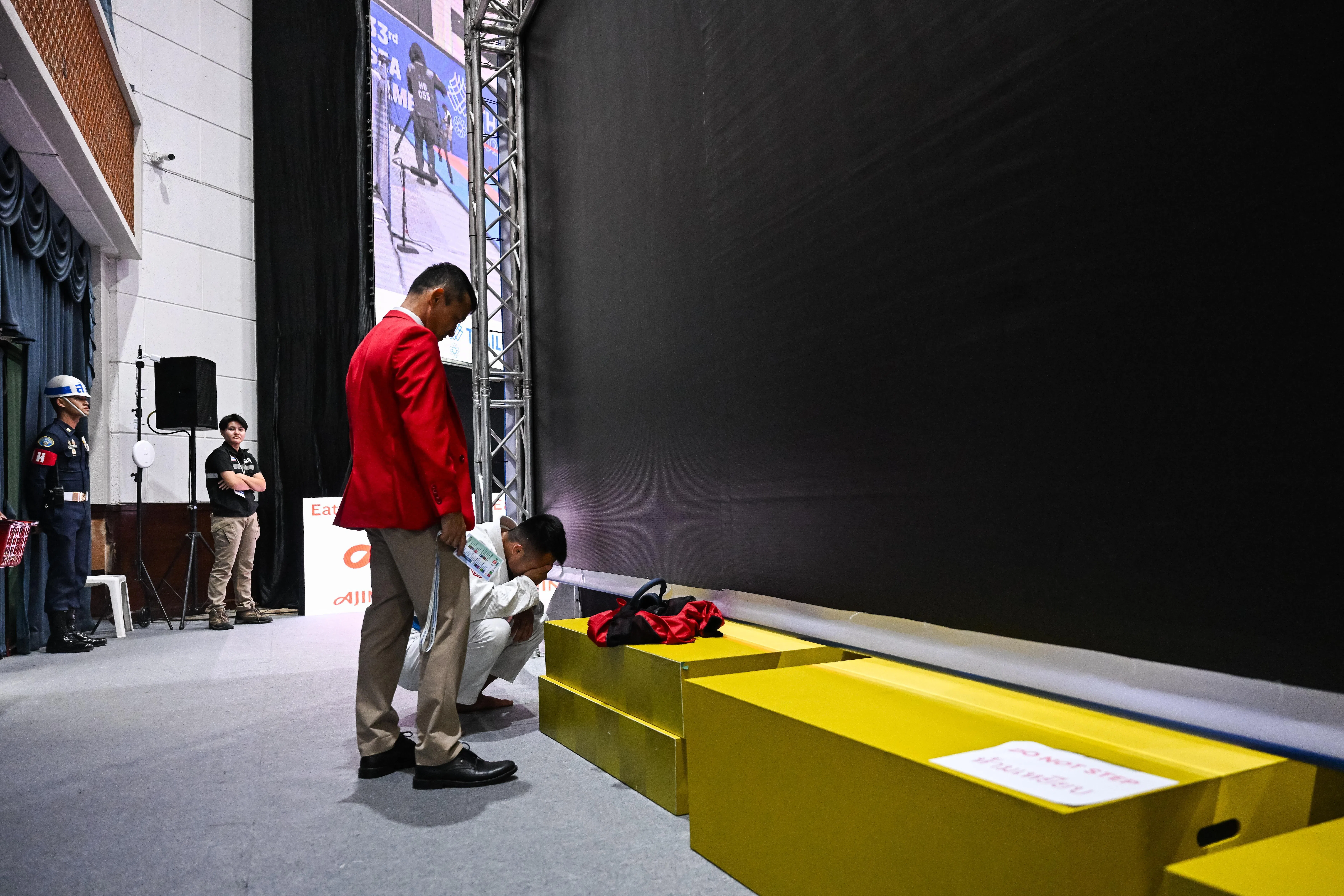 俞厚煜（白衣）赛后情绪激动，蹲下强忍泪水。（每日新闻）