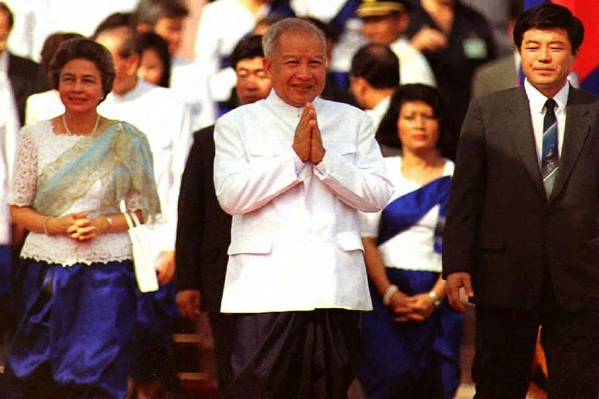1993年9月24日，柬埔寨前国王西哈努克在签署新宪法后重祚，并向金边皇宫里的民众致意。（法新社）