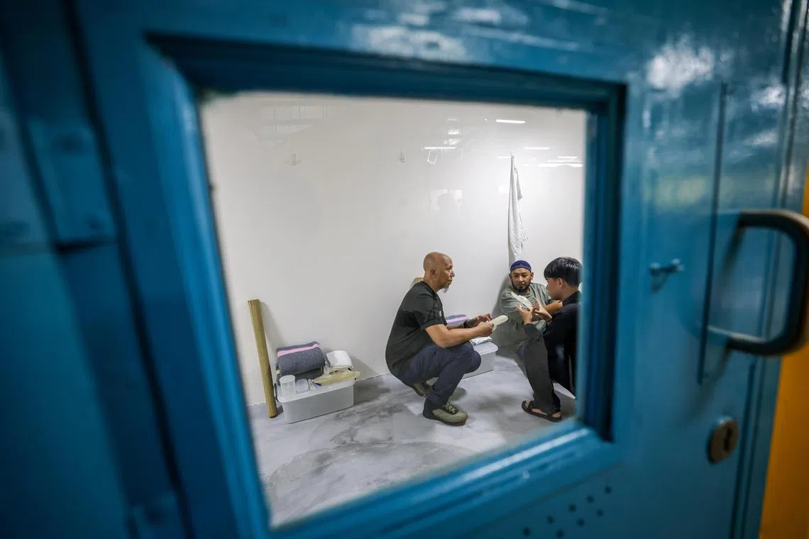 仿真四人牢房设施简陋，空间只够“囚犯”们席地而坐。（叶振忠摄）