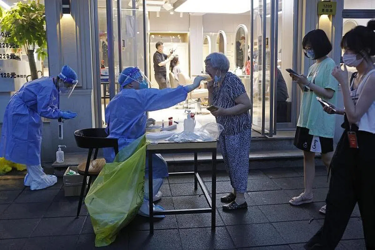 核酸检测已成为许多大城市居民生活的一部分。图为上海居民正在排队进行核酸检测。（中新社）