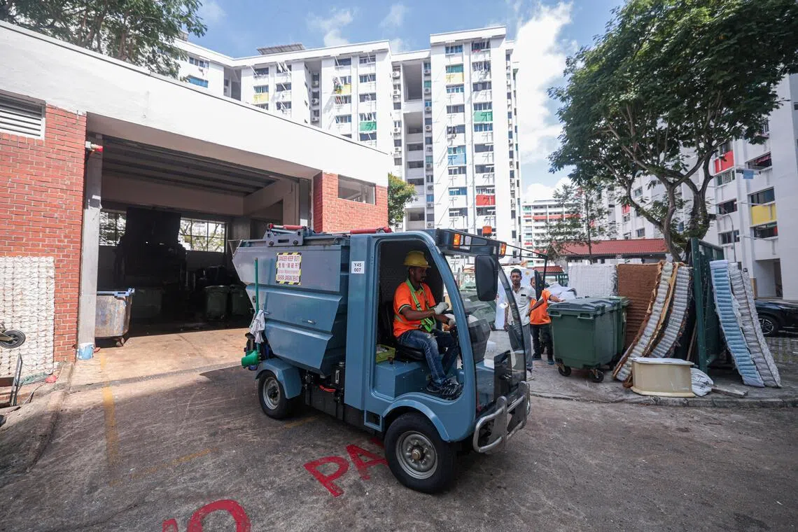 新款垃圾回收车一次可处理12个垃圾槽，相当于约840公斤垃圾；一天运作下来，可服务约20座组屋，总处理量约8400公斤。图为清洁工开着新型回收机，将垃圾带回垃圾处理集中点。（李冠卫摄）