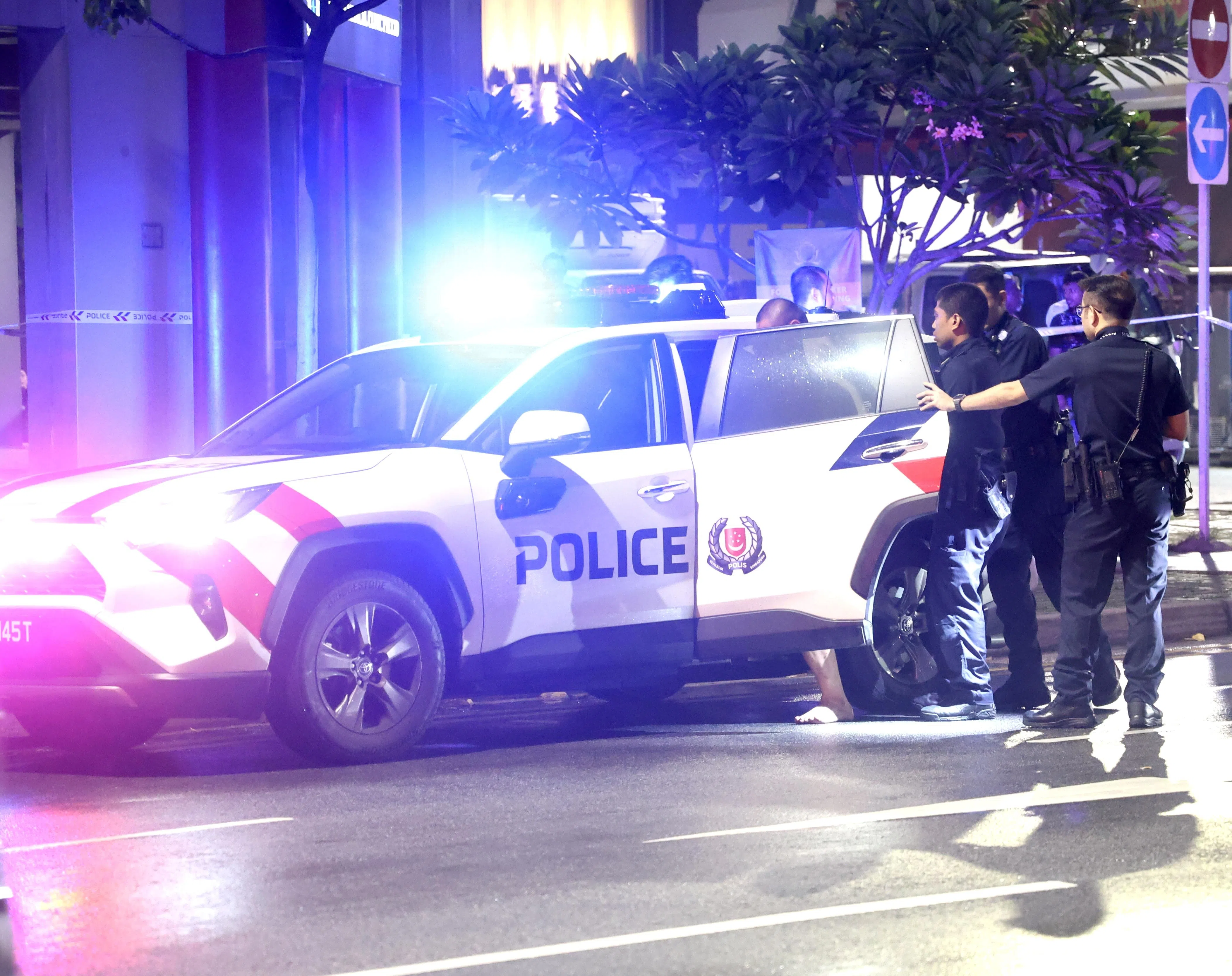 其中一名穿着黑色短裤的男子，不久后被押上警车。（
邬福梁摄）