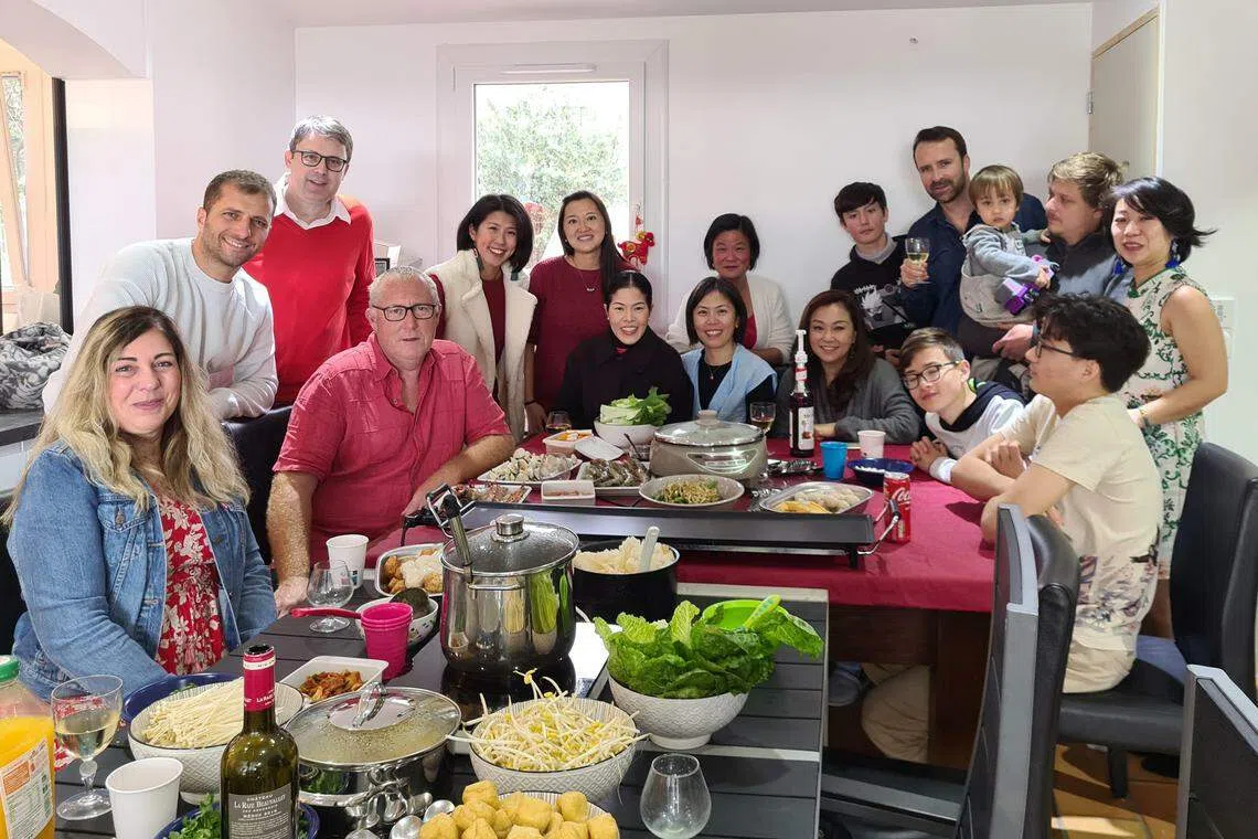 定居法国的罗玉美（后排左三）大年初一与当地的新法跨国家庭相聚吃团圆饭，共度佳节。（受访者提供）