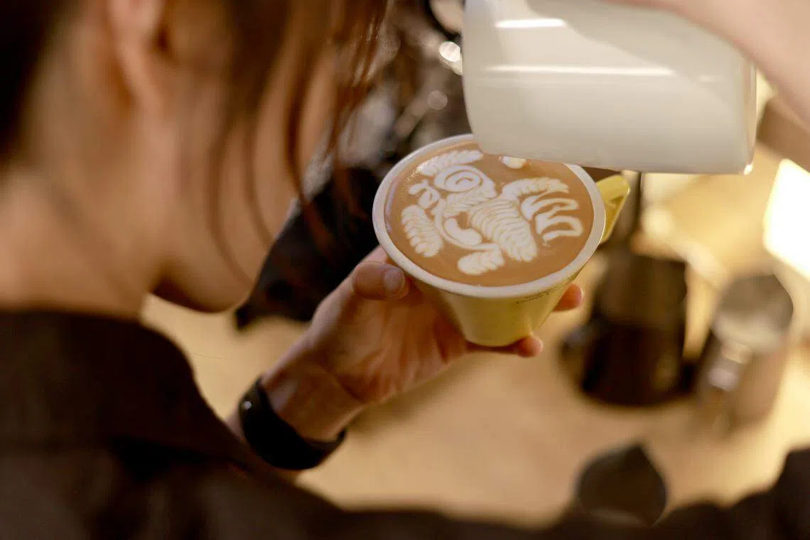 陈佳敏享受制作咖啡拉花的过程。（龙国雄摄）