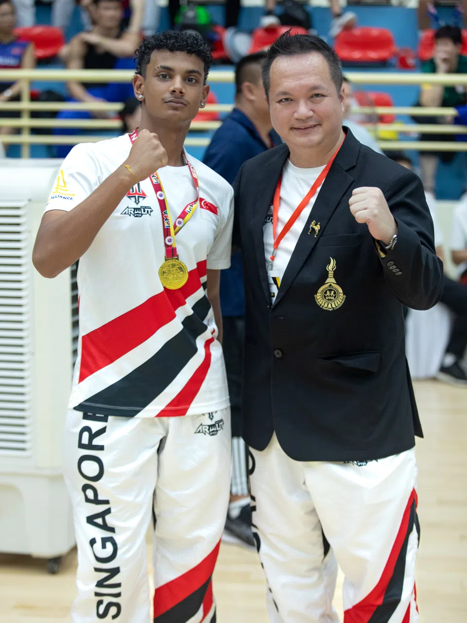 我国首名残障泰拳手米什拉（左）夺得我国首枚残疾泰拳项目金牌，新加坡泰拳总会会长陈沿霏（右）为他送上祝福。（新加坡泰拳总会提供）