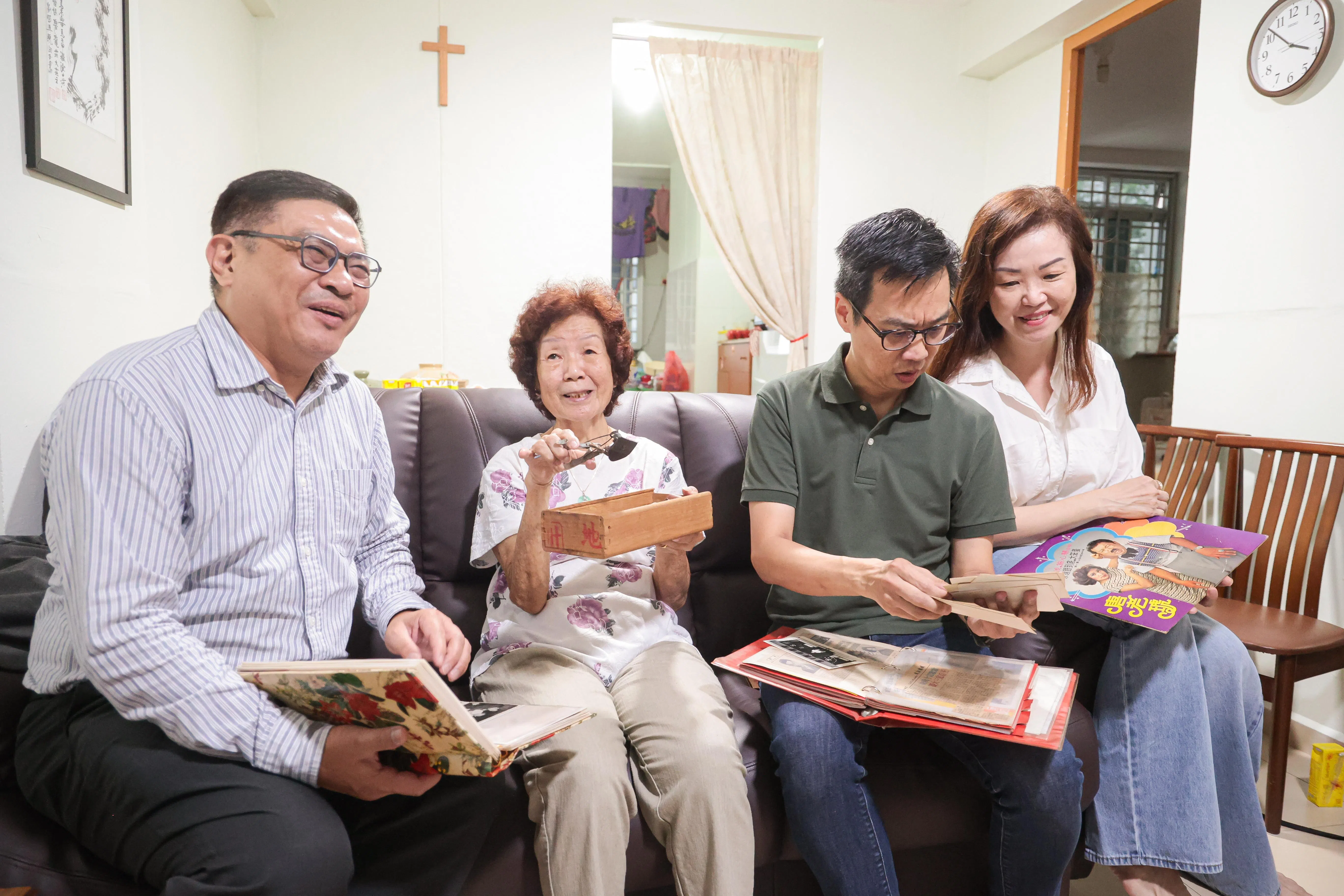 国大图书馆副馆长沈俊平（左起）从唐琥家人包括遗孀蒋亚嫒、儿子振铨和女儿洁思手中接过遗物。（李冠卫摄）