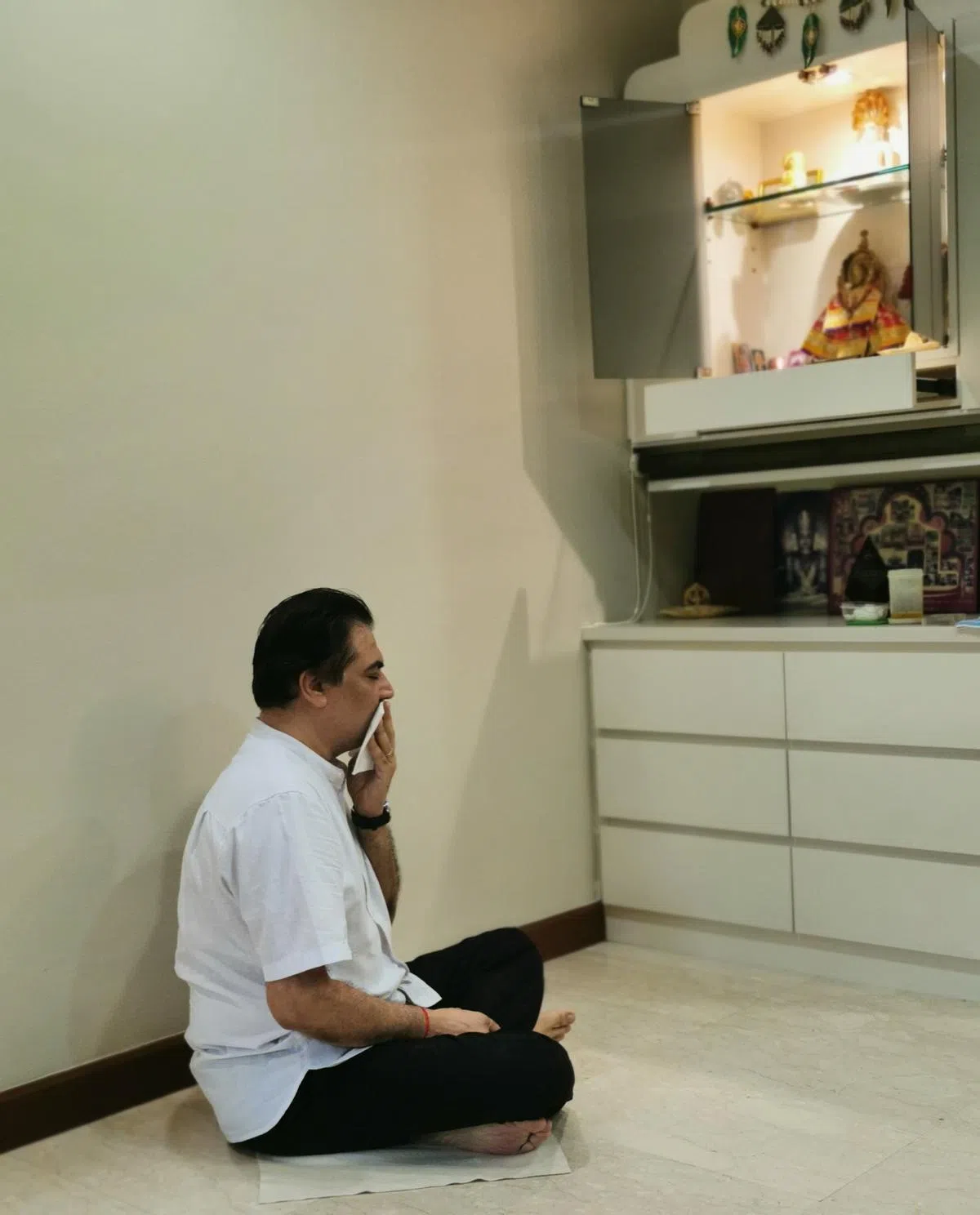 每天48分钟的冥想时间，沙拉日会坐在白布上，用一小块白布遮住嘴白念经。（陈爱薇摄）