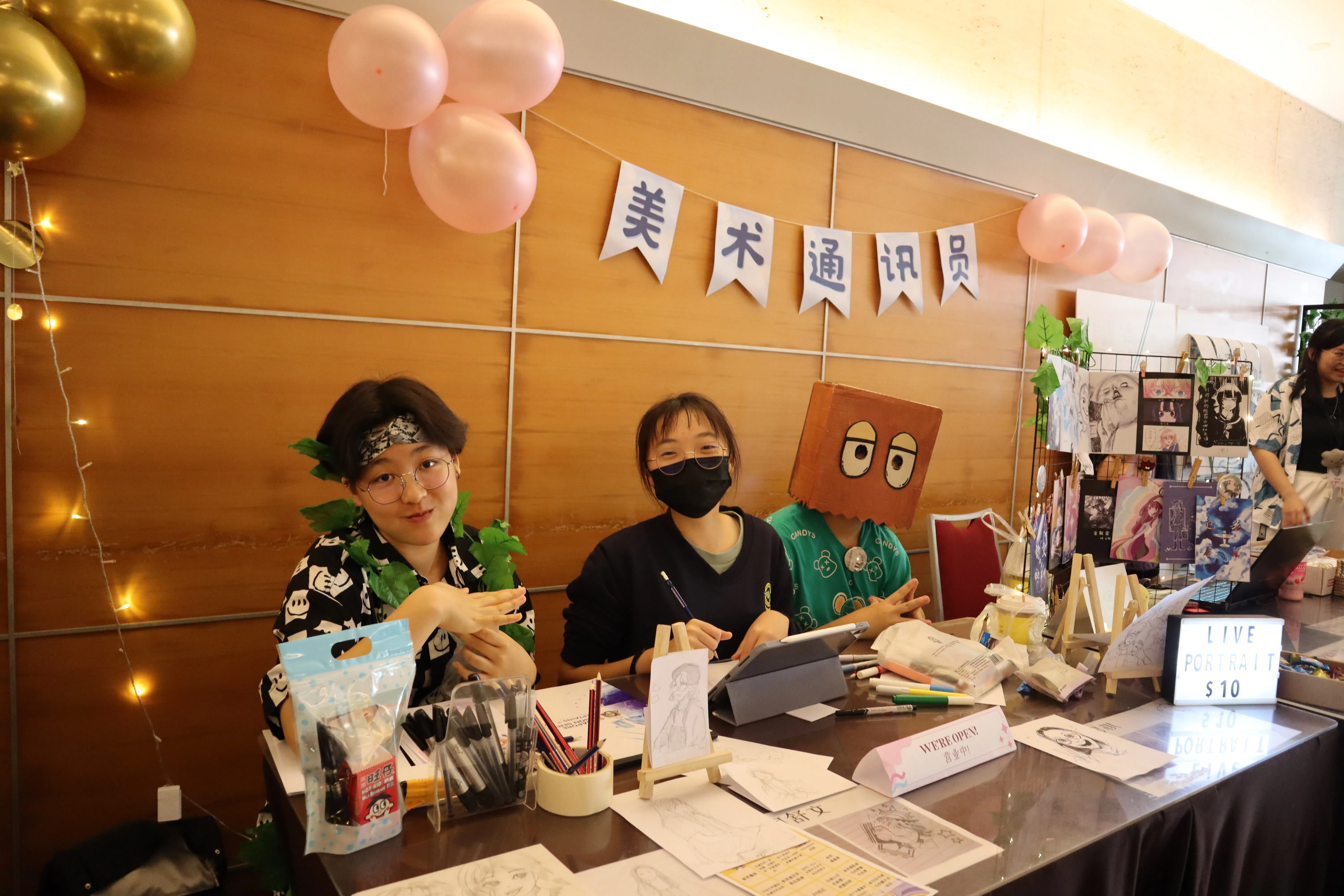 美术通讯员在小市集上大显身手，为出席者提供现场画肖像的服务。（摄影通讯员刘瑞怡摄）