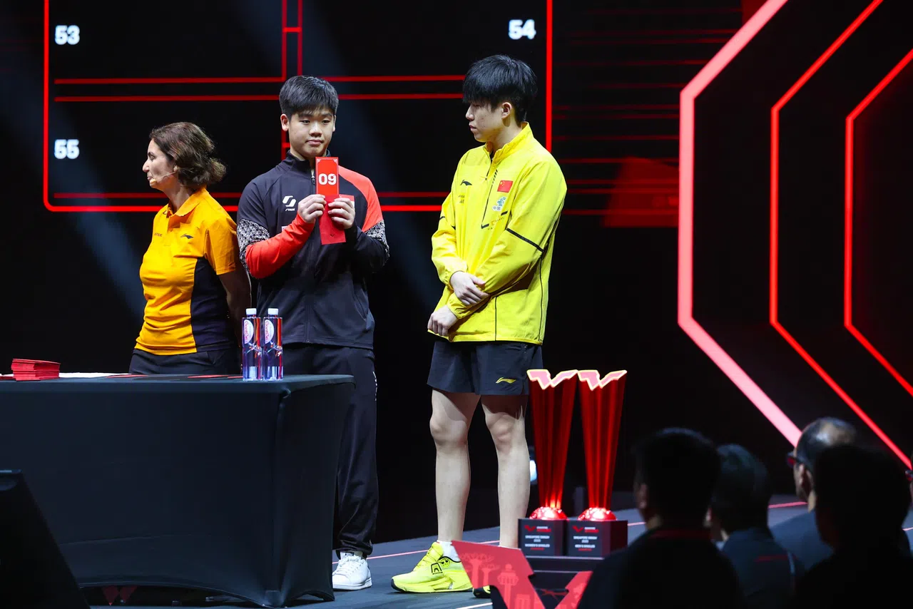 郭勇（中）和王楚钦以抽红包的方式揭晓女单项目的对阵表。（林明顺摄）