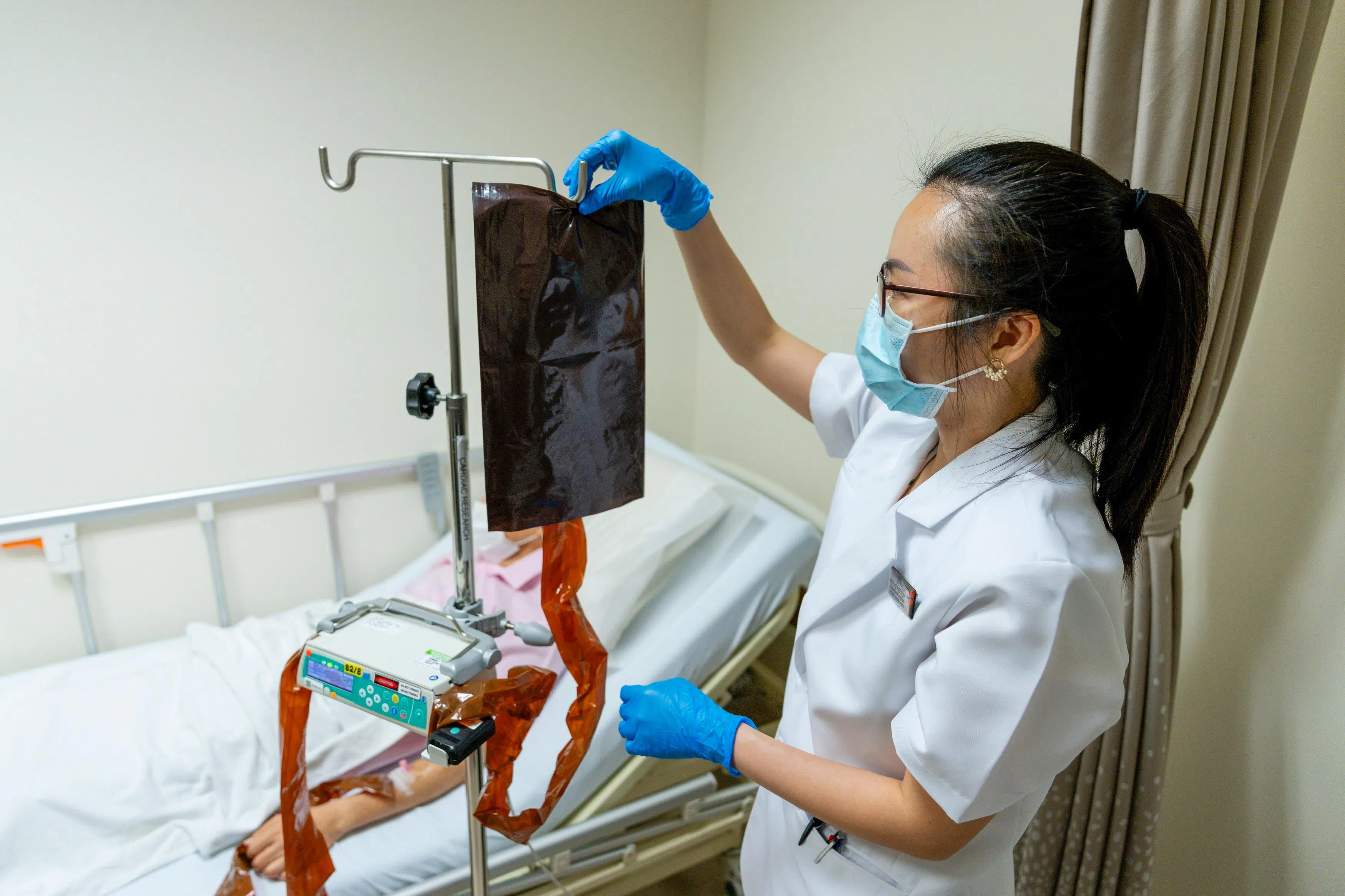 国大心脏中心高级临床研究协调员陈欣怡，正在为参加基因编辑临床试验的患者进行单次静脉注射。（新加坡国立大学心脏中心提供）