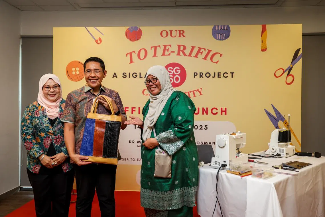 总理公署部长兼教育部和外交部第二部长孟理齐博士（中）为“棒棒善心包计划”主持推介仪式。左为孟理齐夫人萨迪亚（Sadiah Shahal），右为实乞纳民众俱乐部升级再造兴趣小组的成员西蒂（Siti Rahmah）。（叶振忠摄）