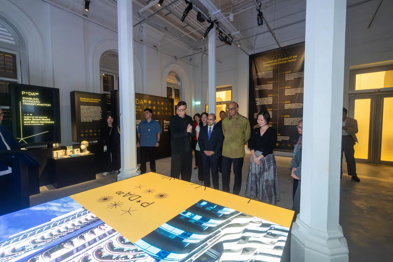 PDA 20展览设计师陈俊达（左一）给尚达曼总统（左三）导览总统设计奖20周年展。 （吴先邦摄）