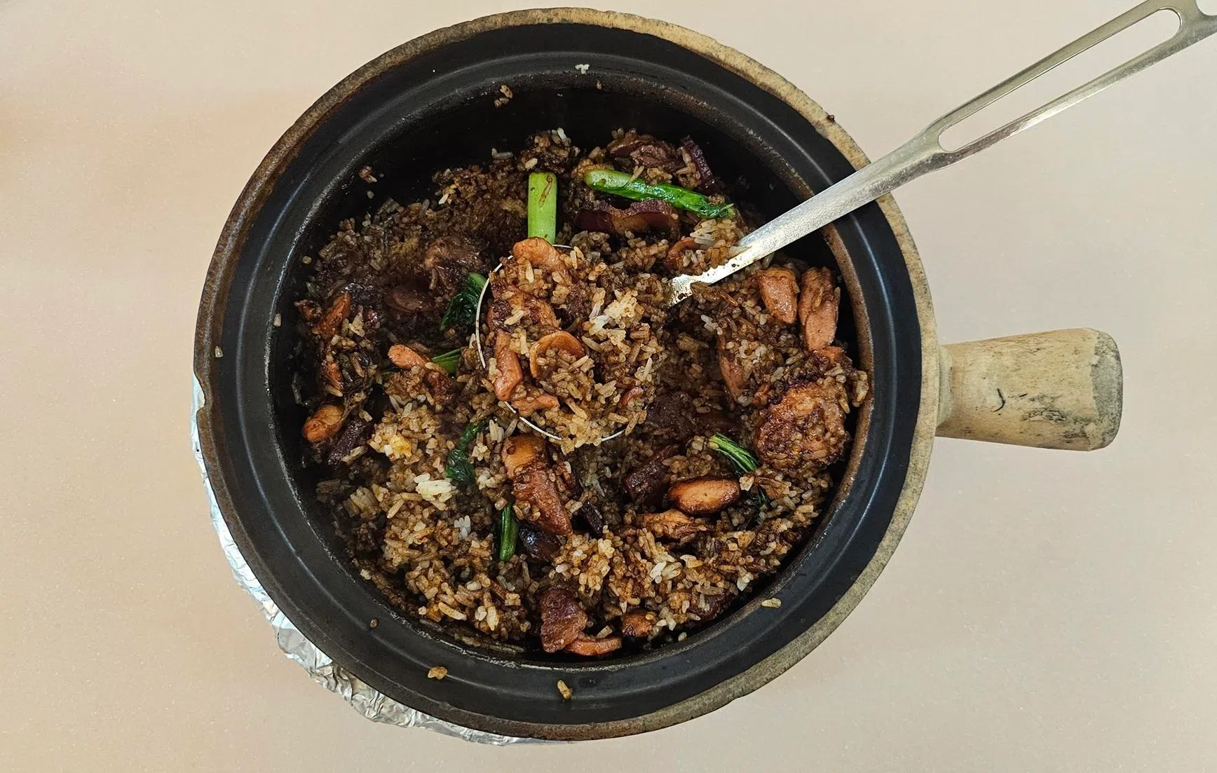 招牌腊味滑鸡饭集合鸡腿肉的油香，腊肠的甜润和咸鱼的咸鲜。（黄亿敏摄）