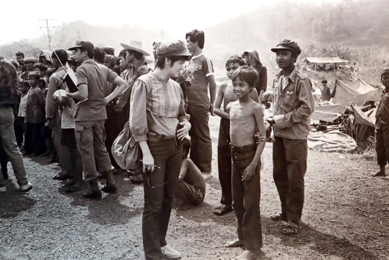 1985年2月旱季，刘培芳访问逃到考沙拉批山麓搭棚而居的柬埔寨难民。她头上戴着抗越游击队员送给她的军帽。（刘培芳提供）