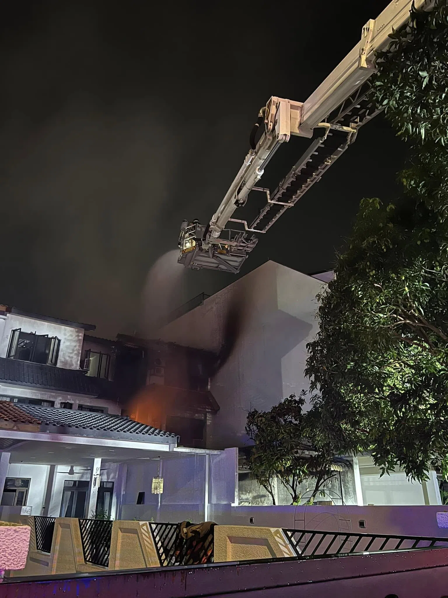 民防部队出动云梯，从高处洒水灭火。（取自新加坡民防部队脸书）