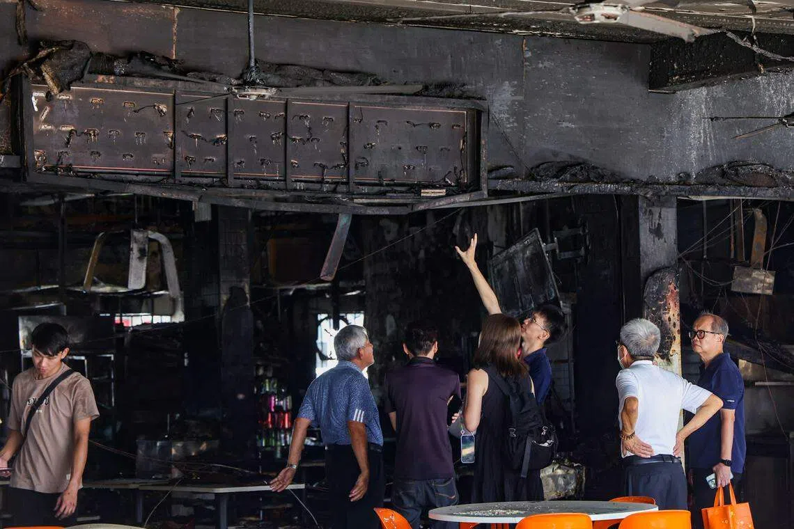 咖啡店业主和各方视察失火后的情况。（白艳琳摄）