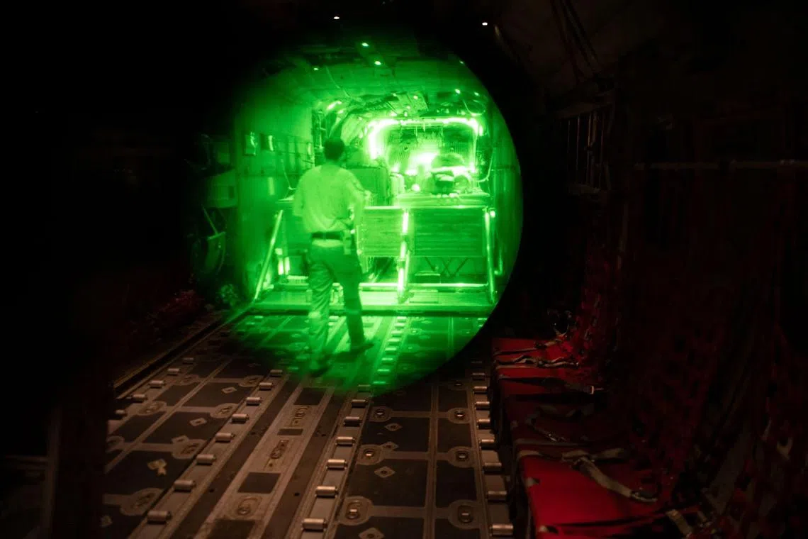 以色列军方星期天（7月27日）发布的照片显示，一名士兵在一架飞越加沙地带的军用飞机上，准备执行人道援助空投任务。（法新社）