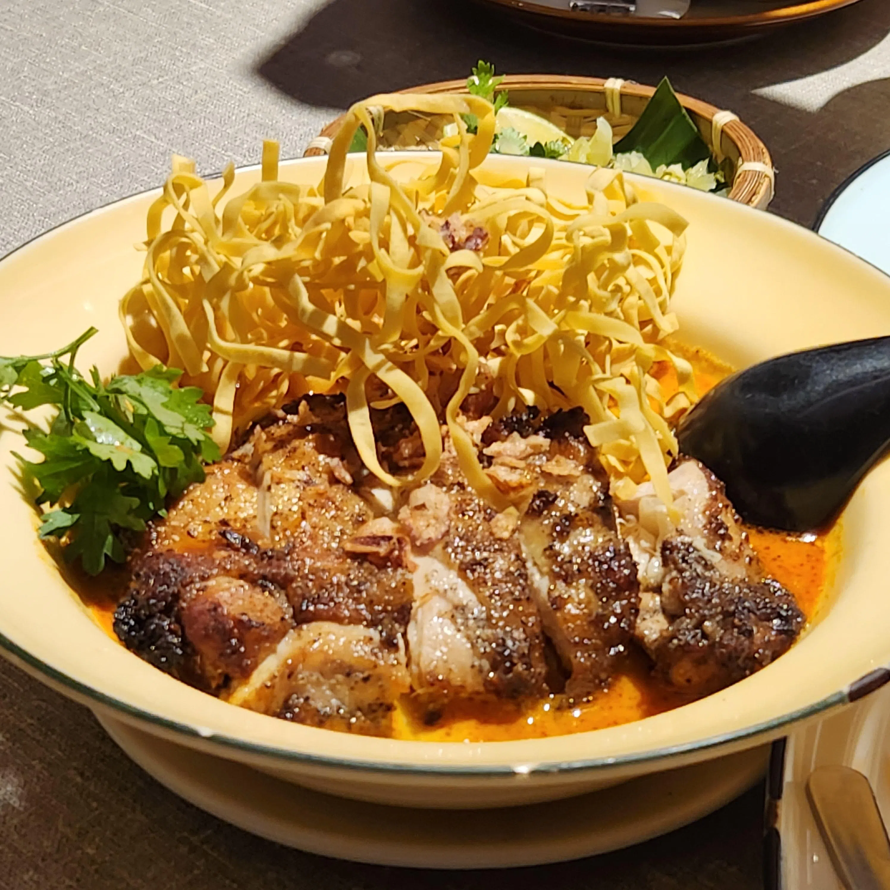 Khao Soi是一面两食的泰北面食，Un Yang Kor Dai版本加了烤鸡。（陈爱薇摄）