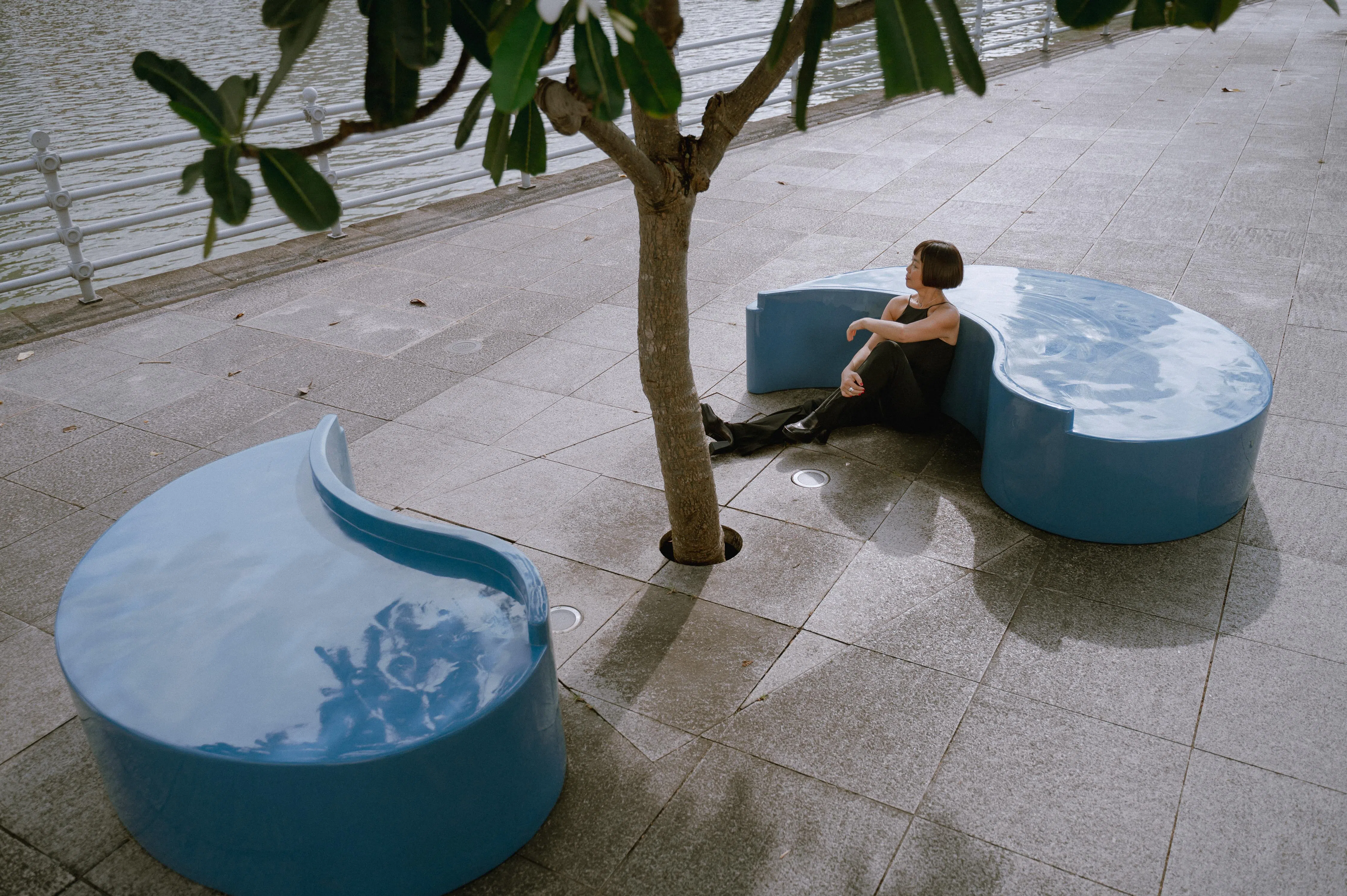 作曲家许美端在新加坡河畔一棵树下，将长凳设想为一个舞台。（艺术之家提供）