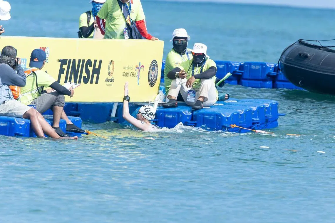 我国小将王盈洁（中）在峇厘岛东南亚公开水域锦标赛的冲线瞬间。（新加坡泳联提供）