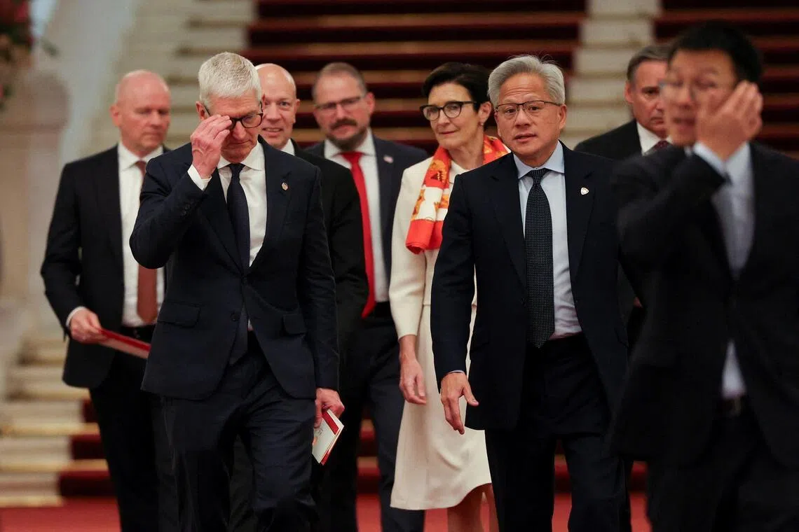 近20名美国商界领袖随特朗普访华，图为英伟达总裁黄仁勋（前排右）、苹果总裁库克（前排左）和花旗集团首席执行官范洁恩（白衣）等美国企业巨头星期四（5月14日）下午在北京人民大会堂。（路透社）