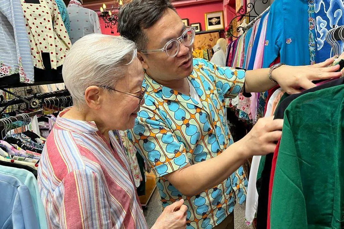 林方伟在卡峇雅专卖店为刘太选择纱笼卡峇雅。（林方伟提供）
